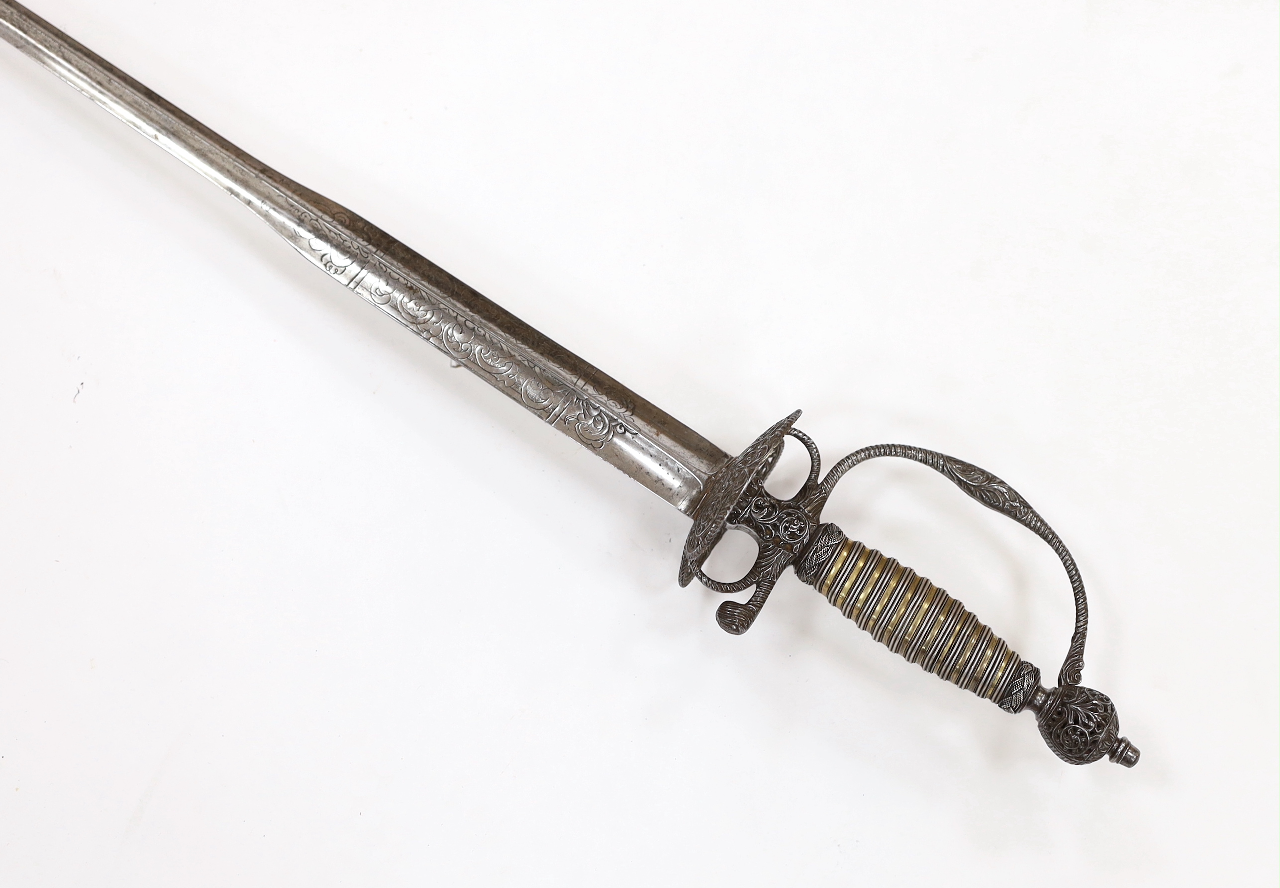 An English iron hilted small sword, c.1765, chiselled and pierced with scrolling devices and foliage, silver gilt tape and silver wire bound grip, colichemarde blade etched with scrolls and squirrel, blade 81.5cm
